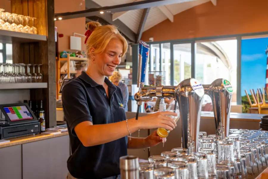 Vakantiemedewerker achter de bar Strandcamping Duinoord Ameland